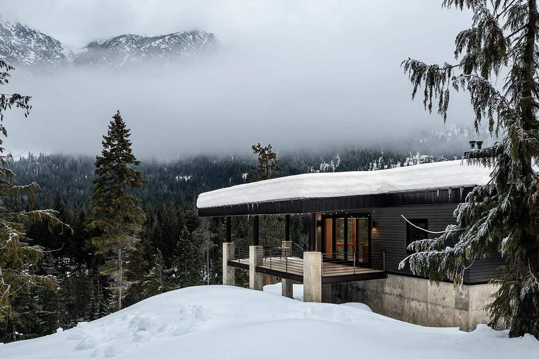 mountain cabin in heavy snowfall, architectural exterior, dramatic winter light
